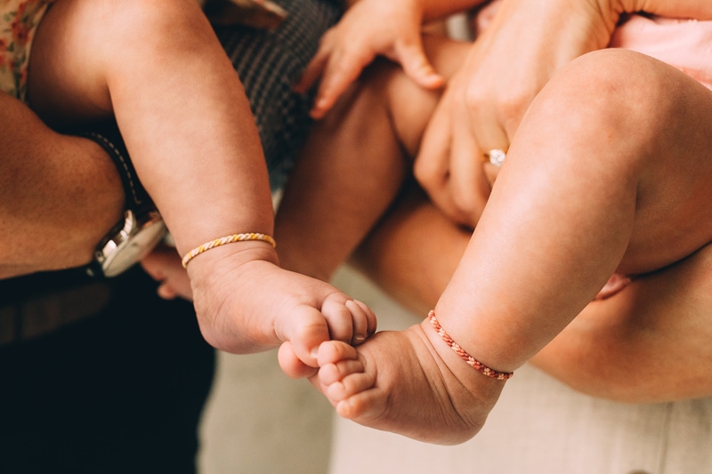 Family Photography -  two babies are being held by their parents, their toes touch