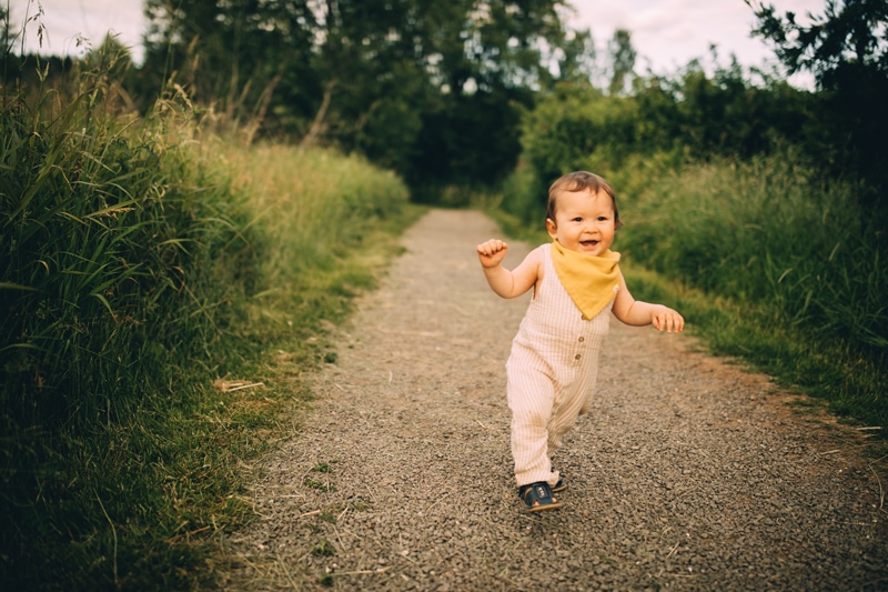 Family Photography, a baby boy runs in a country trail happy