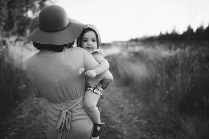Motherhood Photography, a mother walks with her baby girl outside on a country road