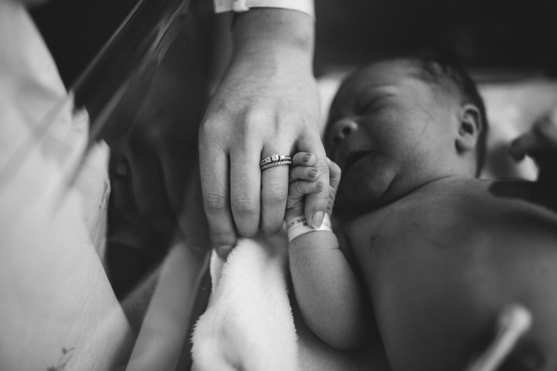 Fresh 48 Newborn Photography, baby in hospital bassinet squeezes moms finger