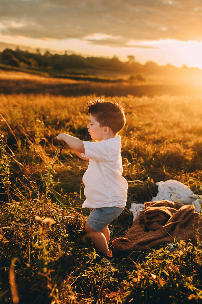 Little boy playing in a field for family photos